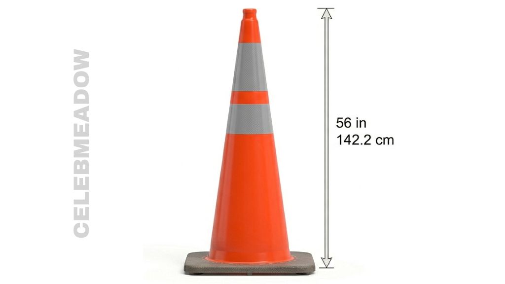 A large orange highway traffic cone standing at 56 inches tall beside a construction zone lane